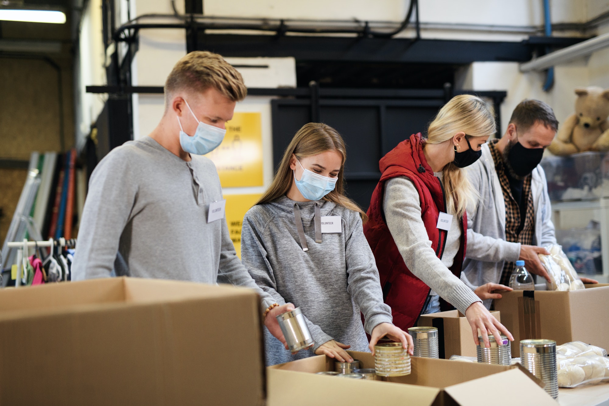 Group Of Volunteers In Community Charity Donation Center Food Bank And Coronavirus Concept  